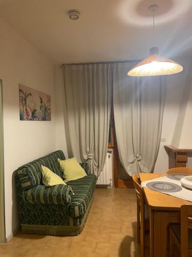a living room with a green couch and a table at Le Pianelle in Pianella