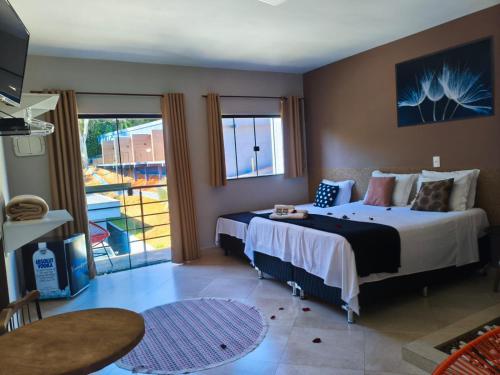 a hotel room with a bed and a balcony at Pousada Recanto da Cascata in Águas de Lindóia