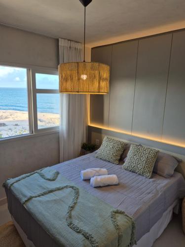 a bedroom with a bed with a view of the ocean at Apto praia paradisíaca - Falésias de Pipa in Pipa