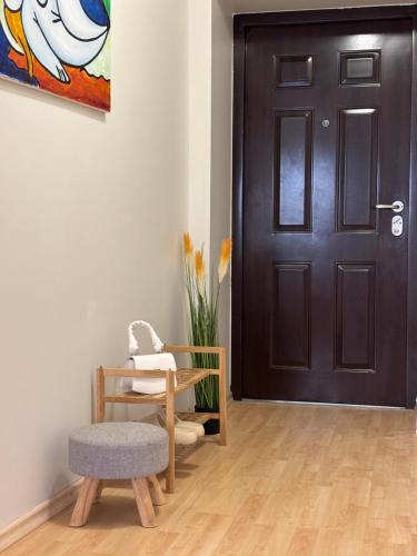 a room with a black door and a chair at Self Check- in Cozy Apartment in Cēsis