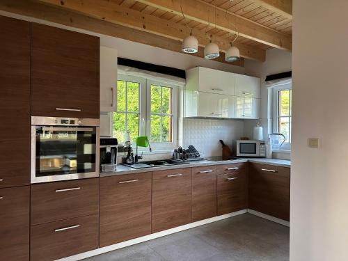 a large kitchen with wooden cabinets and appliances at Anielski Domek in Nieledwia