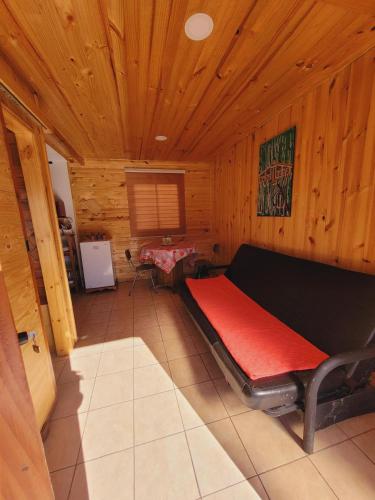 a room with a red bed in a wooden cabin at Killapura in Los Andes