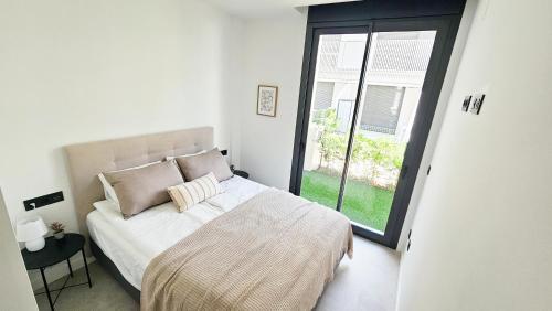 a bedroom with a bed and a large window at Casa Soluna -Santa Rosalia Lake and Life Resort in Torre-Pacheco