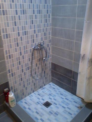 a bathroom with a shower with blue tiles at Apartment Michail in Skála Nikíta