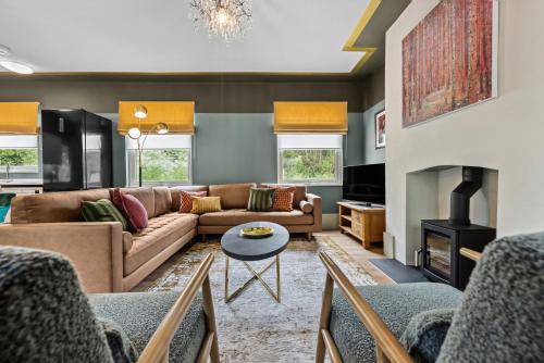 a living room with a couch and a fireplace at The Old Station in Cambridgeshire in Stow cum Quy