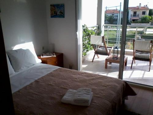 a bedroom with a bed and a balcony with a view at Apartment Michail in Skála Nikíta
