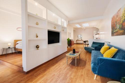 ein Wohnzimmer mit einem blauen Sofa und einem Fernseher in der Unterkunft Lungotevere Trastevere Loft in Rom