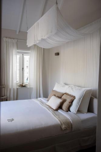 a white bed with two pillows on top of it at Nubia Suites - Boutique luxury appartments in Otrobanda - UNESCO area in Willemstad