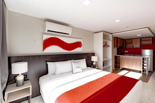 a bedroom with a large white bed and red accents at Ramada Suites by Wyndham Asuncion Aeropuerto in Asuncion