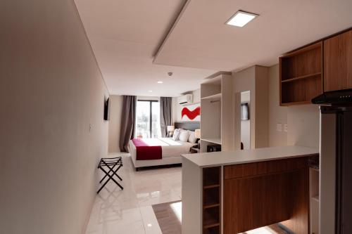 a kitchen and living room with a bed in a room at Ramada Suites by Wyndham Asuncion Aeropuerto in Asuncion