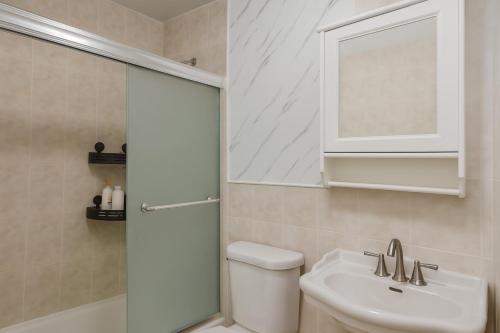 a bathroom with a toilet and a sink and a mirror at 3BR & 2Bath Bronx Stay-Private Suite-Parking in Bronx