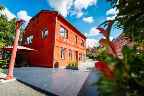 a red building with a pole in front of it at Pension Merano in Jetřichovice