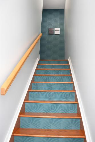 a staircase with blue carpet and a green door at 3BR & 2Bath Bronx Stay-Private Suite-Parking in Bronx