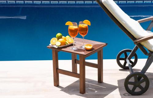 a table with two glasses of orange juice and a bowl of fruit at VILLA NABRISA MARBELLA, 5 BEDROOM, PRIVATE POOL, GARDEN, BBQ in Marbella