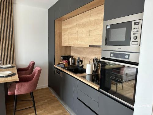 a kitchen with a stove top oven and a microwave at Apartment Lumar in Ljubuški