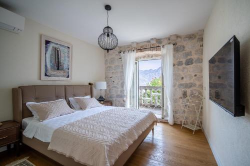 Un dormitorio con una cama grande y una ventana en Villa Carmen, en Kotor