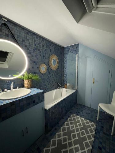 a bathroom with a tub and a sink and a bath tub at Cottage du collectionneur in Saint-Laurent-du-Mottay