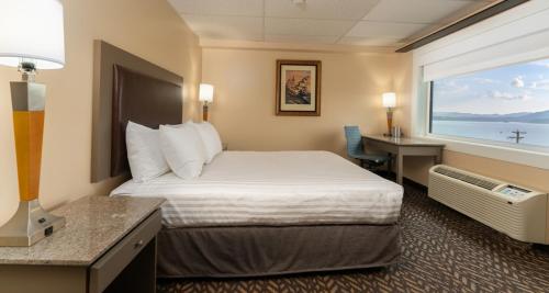 a hotel room with a bed and a window at Prestige Oceanview Hotel Prince Rupert in Prince Rupert