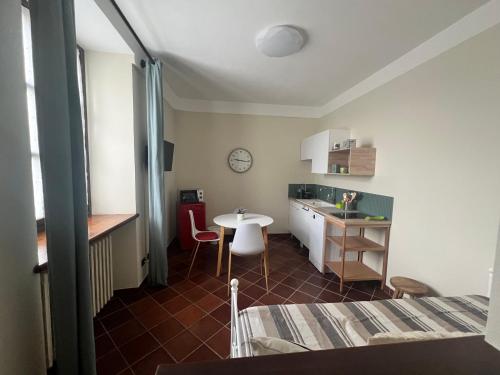 a small room with a bed and a table and a kitchen at Cascina Santa Marta in Fossano