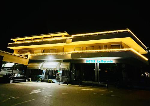 a hotel building with a parking lot at night at Hotel La Bussola in Padenghe sul Garda