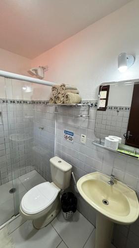 a bathroom with a toilet and a sink at Chales da Lua Juquehy in Juquei