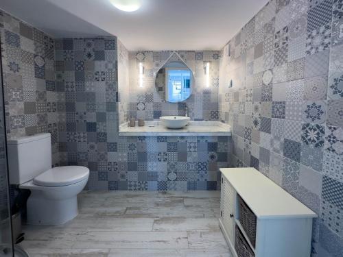 a bathroom with a toilet and a sink and a mirror at Queen's Ocean Sight - Guest House in Cascais
