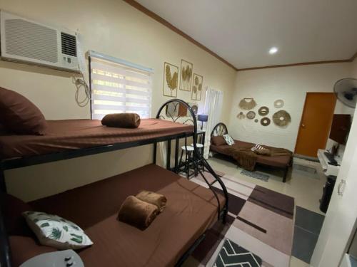 a room with a bunk bed and a couch at Dhenish's Transient House in Pagbilao