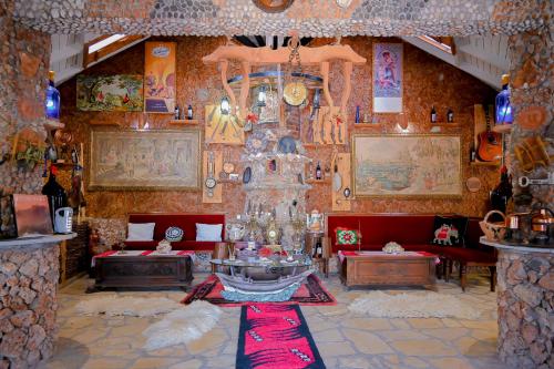 a living room with red couches and a wall with paintings at Bujtina Syni Zi "Keshtjella" - Shengjin in Shëngjin