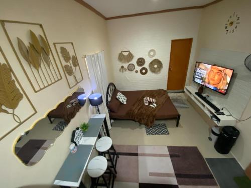 a living room with a couch and a tv at Dhenish's Transient House in Pagbilao