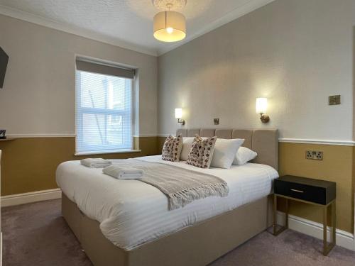 a bedroom with a large bed with a window at Wedgwood Hotel, Orme Room in Llandudno