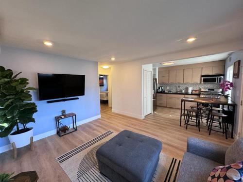 a living room with a couch and a tv on a wall at BBQ Grill 5 mins to DT Canyon Views Parking in San Diego