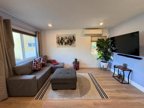 a living room with a couch and a flat screen tv at BBQ Grill 5 mins to DT Canyon Views Parking in San Diego