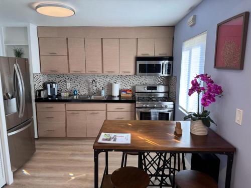 a kitchen with a wooden table and a refrigerator at BBQ Grill 5 mins to DT Canyon Views Parking in San Diego
