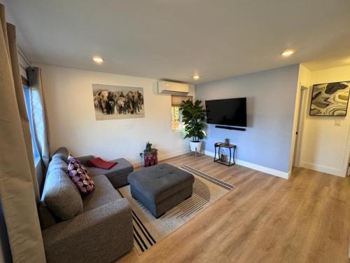 a living room with a couch and a flat screen tv at BBQ Grill 5 mins to DT Canyon Views Parking in San Diego