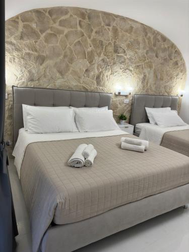 Un dormitorio con dos camas con toallas encima. en Al Fiko Suite, en Catania