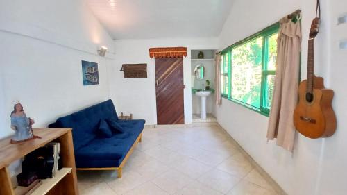 a living room with a blue couch and a guitar at Estalagem Santo André in Santo André