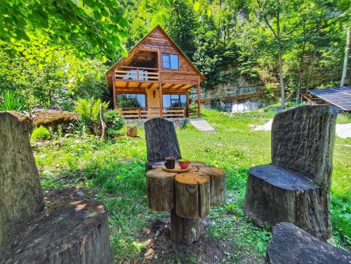 a log cabin with chairs and a table and a house at Getahovit Village & Tours in Getahovit
