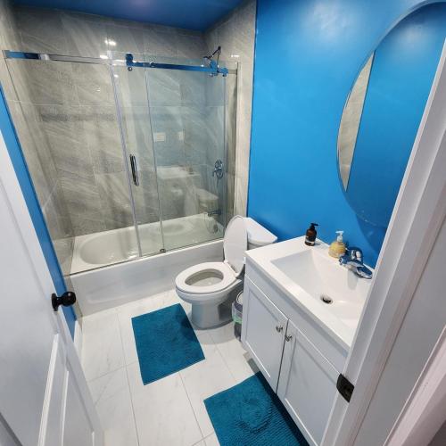 a bathroom with a toilet and a sink and a shower at Gracy's property in Thamesford