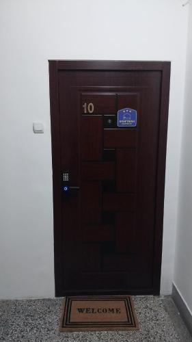 a wooden door with a welcome sign in front of it at Apartman Viševac Vranje in Vranje