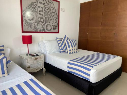 una camera con 2 letti e un comodino con lampada di Frente al Mar home office 7B a Cartagena de Indias