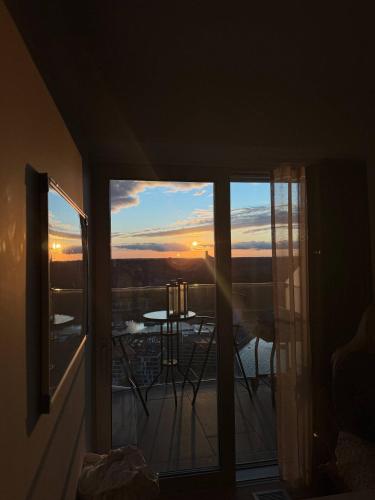 a room with a balcony with a view of a sunset at Lighthouse på Ø - Panoramaudsigt in Aarhus