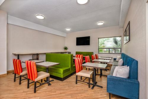 a restaurant with tables and chairs and a flat screen tv at Comfort Inn & Suites in Barrie