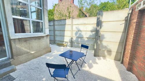 two chairs and a blue table on a patio at Petit cocon à Douai avec jardin et Netflix in Douai
