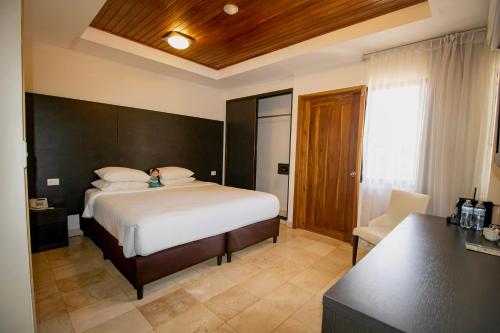 a bedroom with a bed and a desk in a room at Hotel Faranda Guayacanes, a member of Radisson Individuals in Chitré