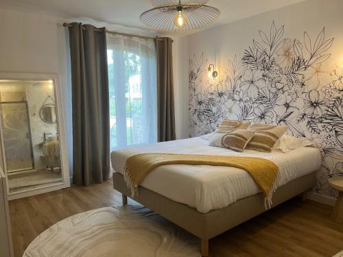 a bedroom with a bed with a flower patterned wall at Villa Simone in Arthémonay