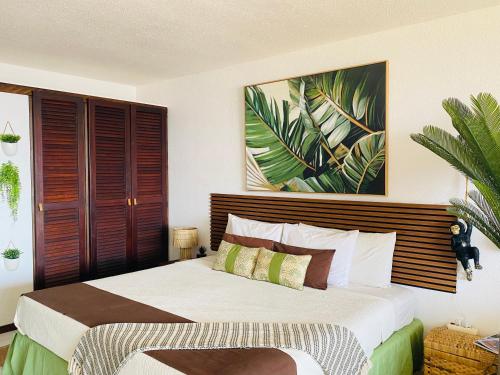 a bedroom with a bed and a painting on the wall at Excellence Suites Orient Beach Oceanview King-Size Beach Pool Parking in Cul de Sac