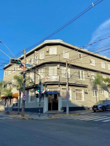 a building on the corner of a street with a traffic light at Hotel Avenida Bauru in Bauru