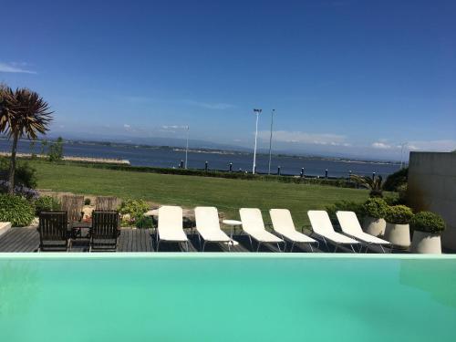 a group of chairs and a table with a view of the ocean at Casa da Ria in Torreira
