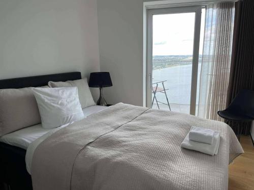 a bedroom with a large bed with a view of the water at Lighthouse på Ø - Panoramaudsigt in Aarhus