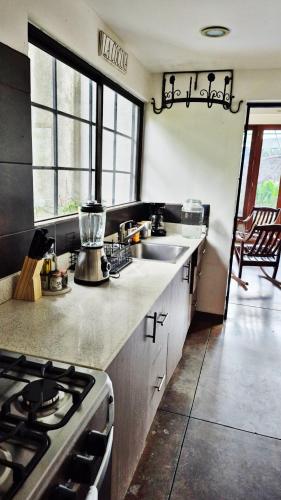 a kitchen with a sink and a stove top oven at Casa Milo in Managua